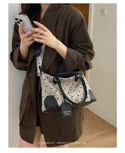 Sac à bandoulière en toile à pois rétro pour femme, design élégant avec poignées et sangle.