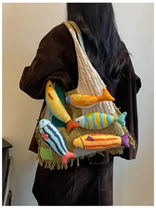 Detailed shot of knitted shoulder tote bag with cute plush fish accents for daily casual wear.