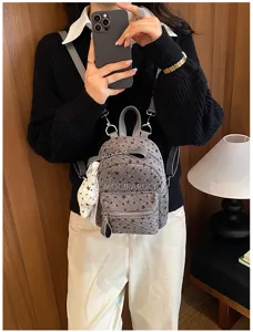 Vue détaillée du mini sac à dos en velours côtelé gris avec imprimé d'étoiles.