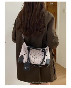 Sac à épaule rétro à pois vue détaillée, design contrasté chic avec poignées noires.