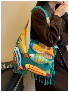 Detail view of a knitted tote bag with 3D fish charms and tassels, stylish casual look.