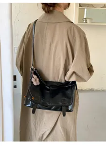 Borsa a tracolla retrò chic in ecopelle nera con dettaglio di ciondolo a fiore lavorato.