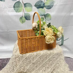 Panier de pique-nique rectangulaire en rotin imitation avec fleurs artificielles.