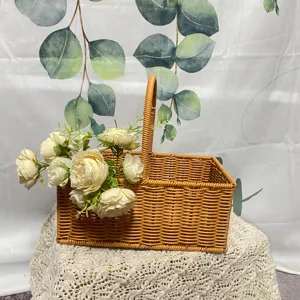 Panier de pique-nique en rotin tissé avec des fleurs artificielles blanches rangement