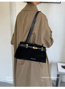 Klassieke zwarte suède schoudertas met chique goud hardware en retro riemdesign.