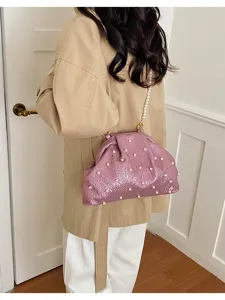 Vue détaillée d'un sac bandoulière rose en perles, élégant sac à main de soirée chic.