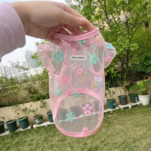 Primo piano dettagliato del grazioso gilet in rete rosa per animali con motivo floreale estivo.