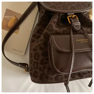 Brown leopard print backpack detail view, casual women bag with front pocket and leather trim.