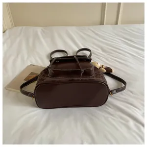 Brown casual backpack with front pocket and drawstring closure, stylish niche design.