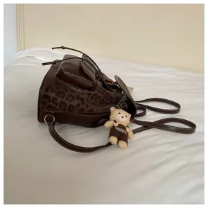 Stylish women casual backpack with leopard print and cute bear pendant, trendy design.