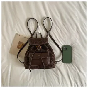 Detailed view of casual brown leopard print backpack with front pocket and shoulder straps.
