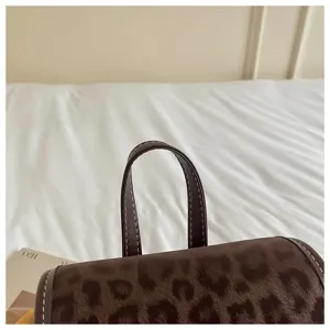 Detailed close-up of a stylish brown leopard print casual backpack handle and stitching.