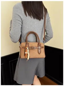 Retro brown suede boston shoulder bag detail view with wooden bead pendant and buckle
