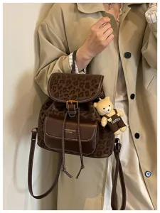 Stylish leopard print casual backpack for women with cute bear pendant and leather trim.