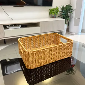 Gedetailleerd overzicht van rieten opbergmand met handgrepen op glazen tafel in woonkamer.