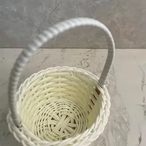 Mini white woven rattan flower basket desktop ornament for floral arrangement and decoration.