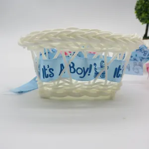 Handmade mini plastic woven flower basket with blue It's A Boy ribbon for baby shower decor.