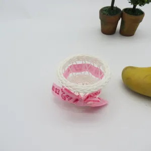 Handmade mini plastic rattan flower basket with pink bow for party favors and home decor.