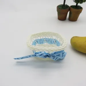 Handmade woven mini rattan flower basket with blue ribbon bow, cute plastic storage basket for decor.