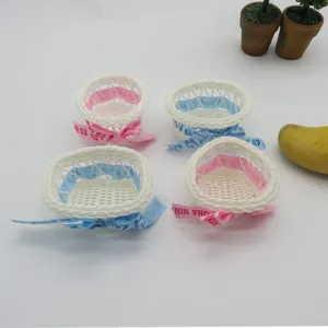Mini handmade woven plastic rattan flower baskets with cute decorative bows for parties.