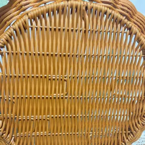 Dettaglio del vassoio portaoggetti in rattan intrecciato a mano con trama ordinata.