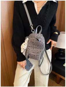 Gros plan détaillé du sac à dos gris avec motif d'étoiles porté, élégant et pratique.