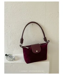Retro suede shoulder bag detail, minimalist design with knot handle and flap closure.