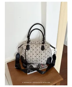 Détail de sac à main à pois rétro, élégant sac bandoulière en toile avec poignée noire.