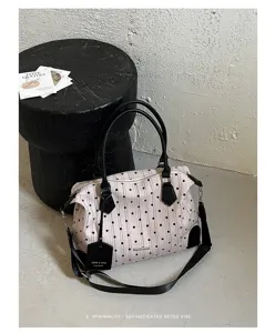 Vue détaillée d'un sac à bandoulière vintage à pois avec une conception unique.