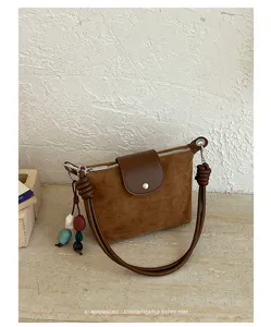 Retro brown suede shoulder bag with chic knotted handle and colorful beaded charm detail.