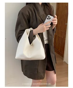 Detalle del elegante bolso hobo plisado blanco minimalista que muestra un diseño.