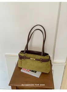 Detailed view of olive green suede shoulder bag with brown leather straps and gold lock.