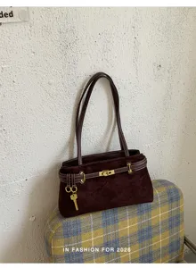 Close-up detail of vintage dark brown suede shoulder bag with metallic lock hardware.
