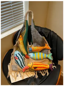 Detailed view of knitted woven tote shoulder bag with colorful fish plush toys, lazy style.