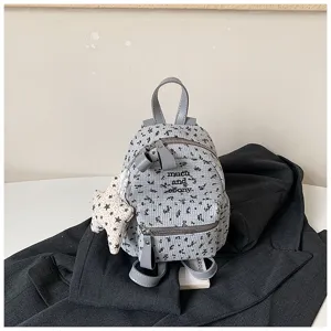 Vue détaillée du mini sac à dos gris à motif floral de style japonais avec un joli pendentif étoile.