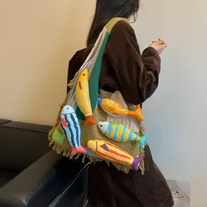 Knitted shoulder tote bag for women, stylish casual commuter woven bag with cute fish plushies.