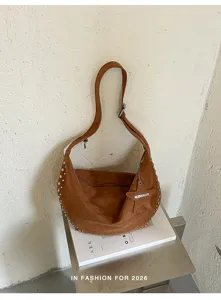 Bruine suède hobo schoudertas met metalen studs en sterrenhangertje, casual dagelijkse stijl.