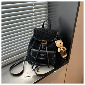 Korean style black leopard print backpack detail showing premium leather fabric material and cute bear pendant.