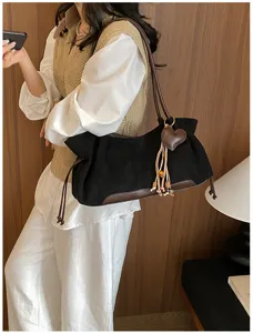 Vintage suede shoulder bag for women, chic underarm tote with heart tassel charm and brown trim.