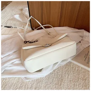 Vista dettagliata di una elegante borsa a tracolla bianca con cinturino e chiusura metallica.