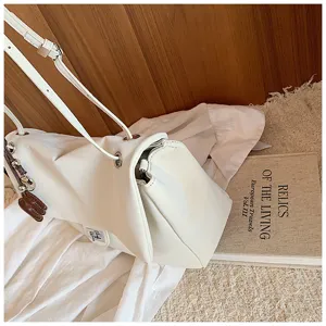 Dettaglio borsa a spalla bianca minimalista, elegante borsa morbida con accessori metallici.