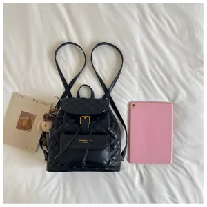 Black quilted leather backpack detail view, featuring front pocket and adjustable straps for daily use.