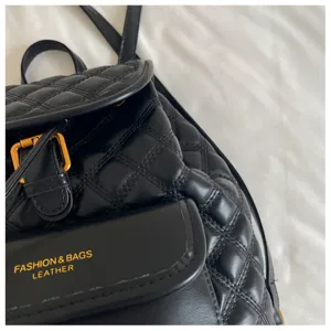 Black quilted leather backpack detail, gold buckle hardware, premium casual bag closeup.