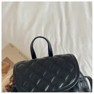 Close-up detail showing the handle and quilted leather texture of the black fashion backpack.