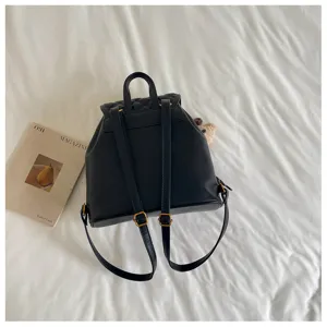 Detailed view of a stylish black faux leather backpack featuring quilted flap and metal buckles.