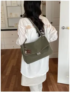 Vista dettagliata della elegante borsa a tracolla verde oliva con patta e chiusura a girello.