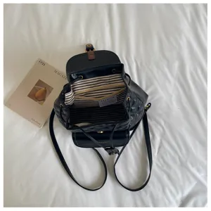Black quilted faux leather backpack with drawstring closure and striped interior lining.