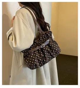 Vista detallada del bolso de hombro plisado con lunares usado por la modelo, estilo casual.