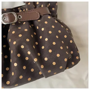 Vista detallada del elegante bolso de hombro plisado con lunares en piel sintética marrón.