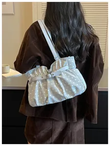 Vista detallada del bolso de hombro fruncido con lunares azules de moda para mujeres.